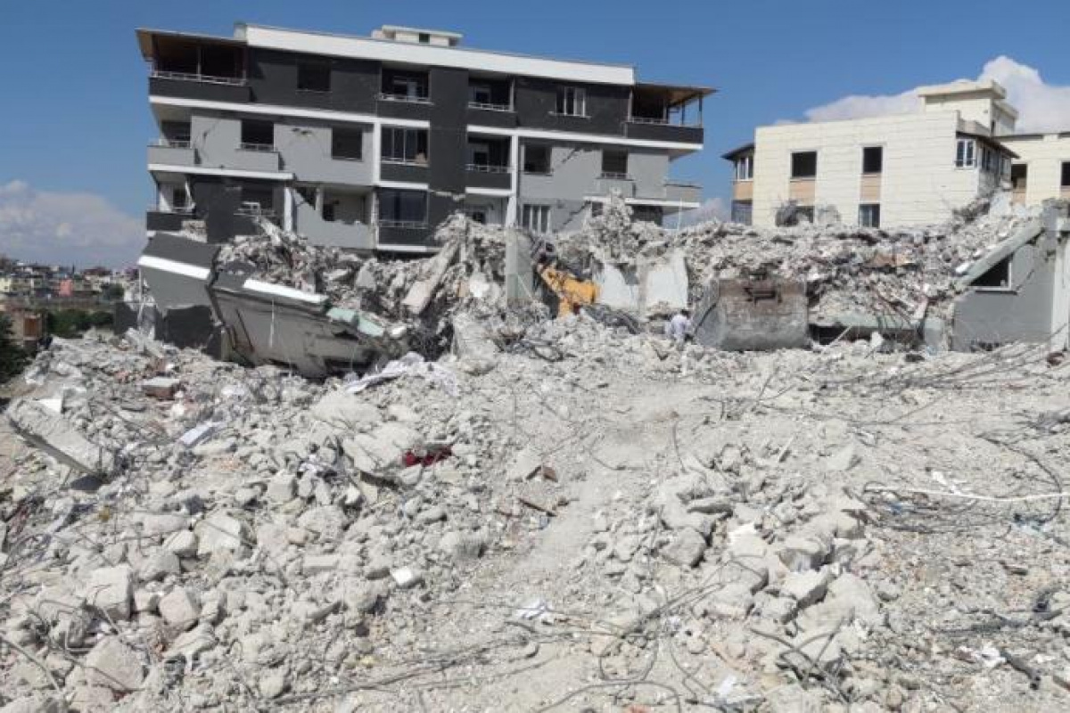 Ağır hasarlı binayı yıkan kepçe operatörü enkaz altında kaldı