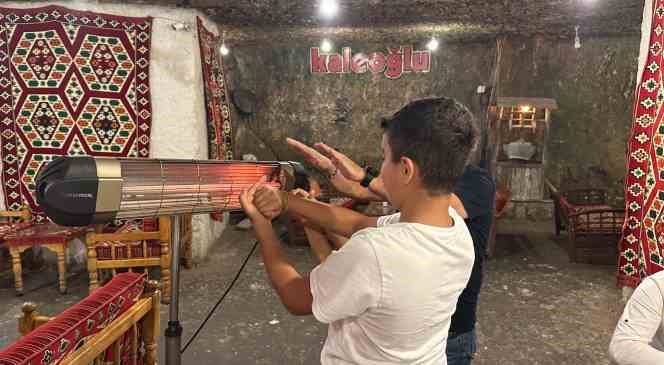 Kavurucu sıcaklarda bu mağarada sobayla ısınıyorlar