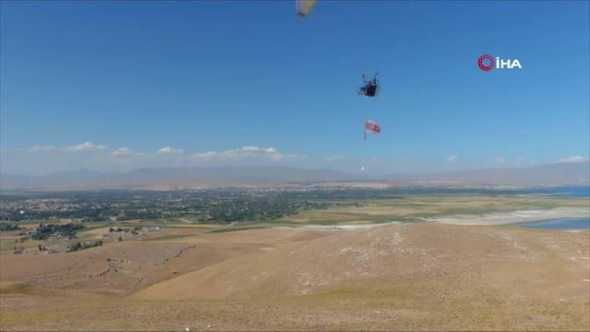 Yamaç paraşütü pilotu baba ve oğul Van Gölü semalarında ‘Erciş il olsun’ pankartı açtı