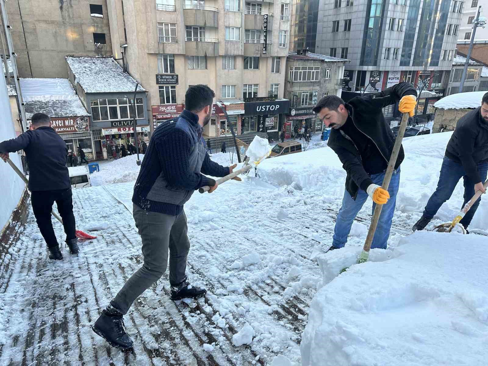 Vatandaşlar çatıdaki kar kütlelerini brandayla indirdi