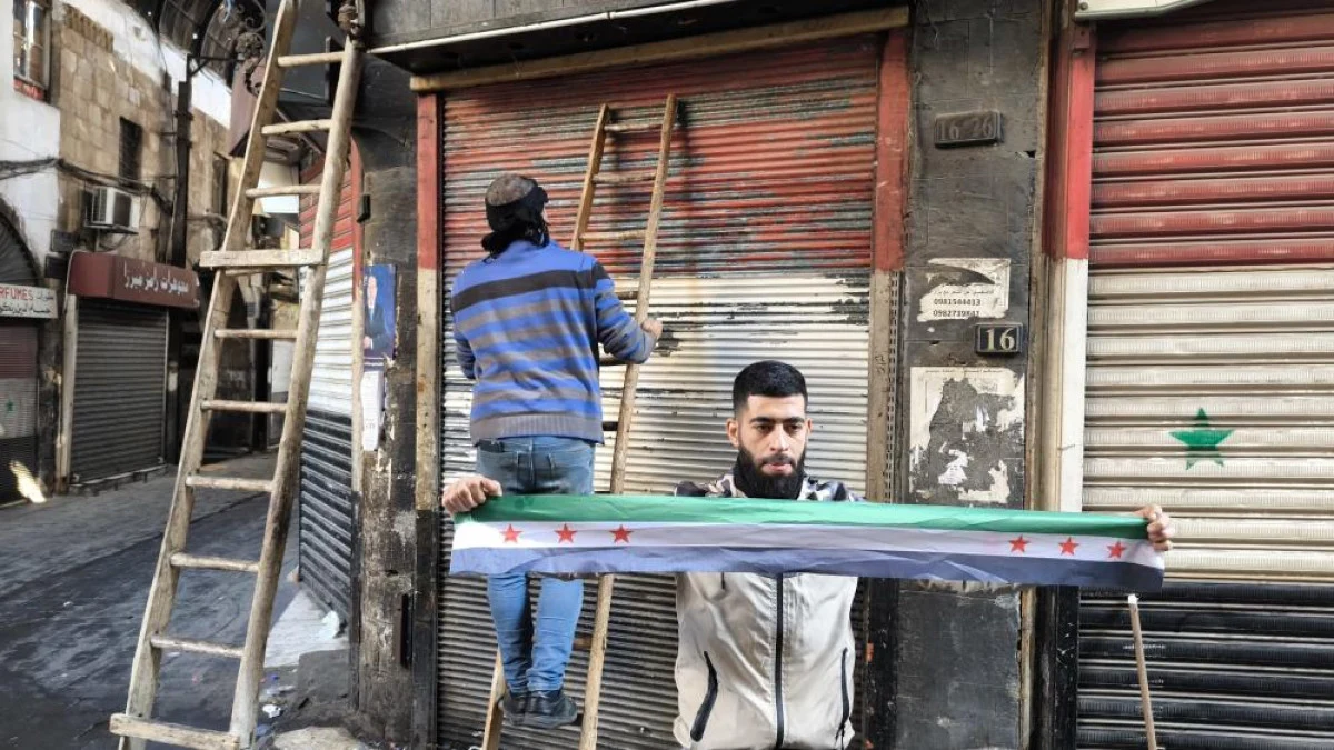 Suriyeli esnaflar, kepenklerindeki eski Suriye bayraklarını kazımaya başladı