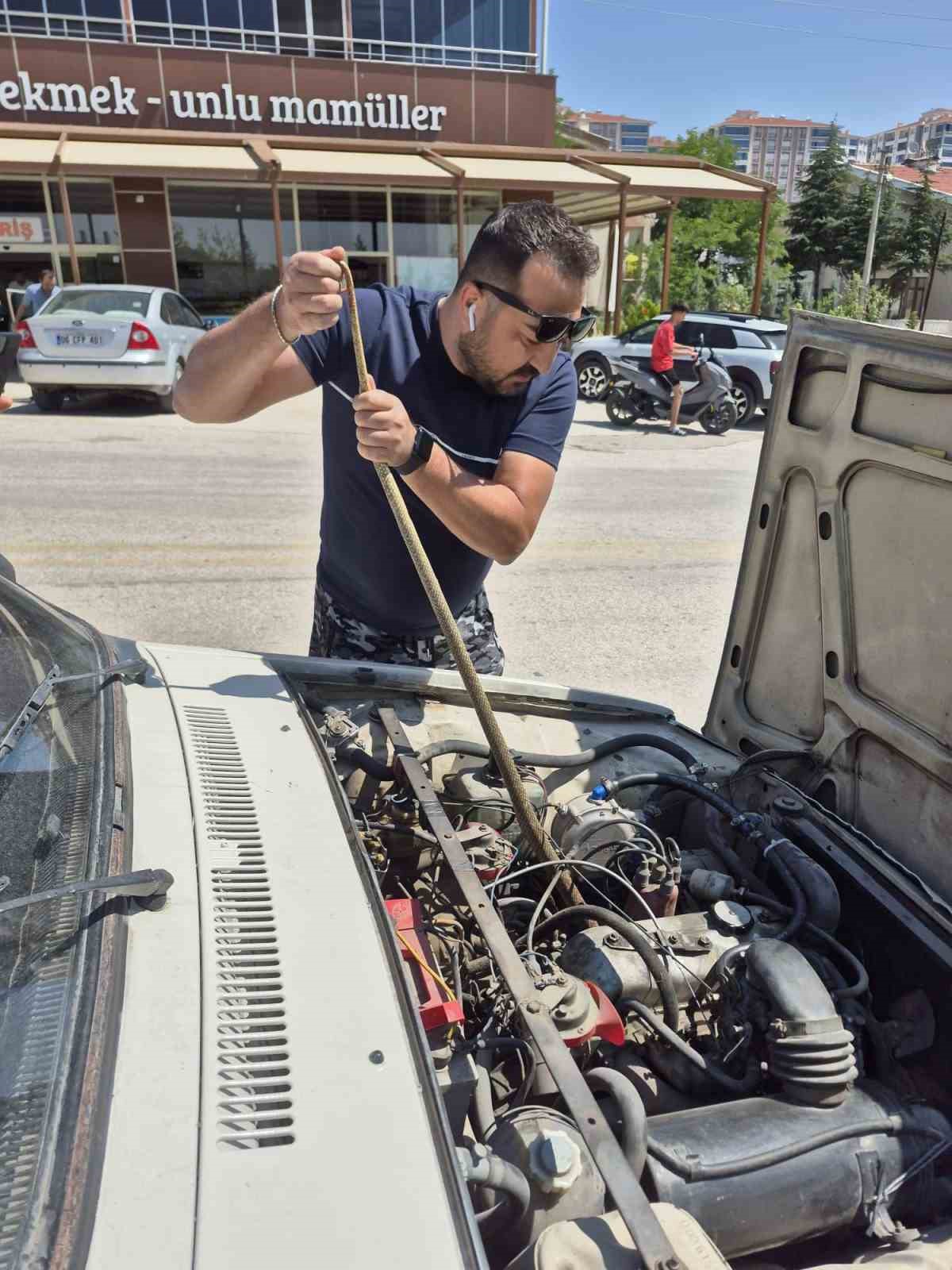 Aracın motoruna giren yılanı elindeki sopayla çıkardı